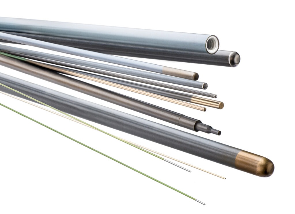 Various metal rods and tubes of different lengths and finishes, arranged in a dynamic arrangement, highlighting materials for engineering or manufacturing applications.
