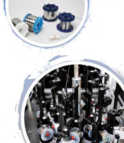 Metal wire spools alongside machinery, illustrating the wire production process. Highlights the industrial context of wiring applications.