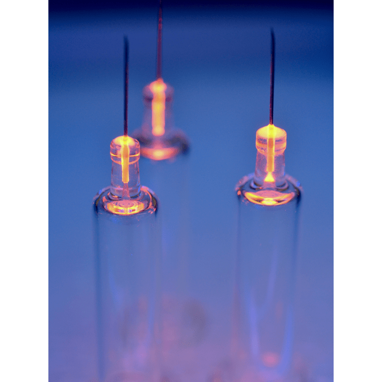 A glowing glass tube with a bright, orange plasma discharge visible at the top, illustrating a gas discharge experiment.