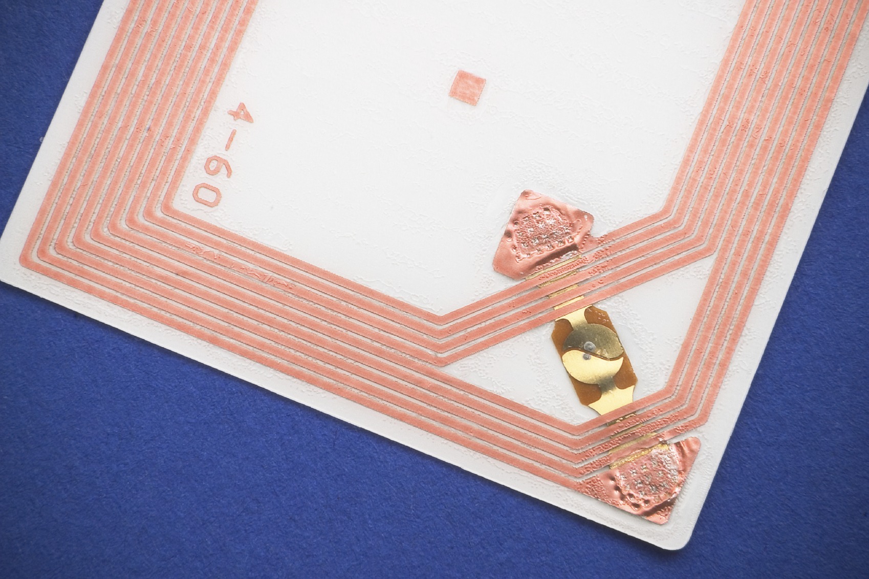 Close-up of an RFID card, showcasing its copper circuit lines and chip. Relevant for discussions on contactless technology and identification systems.