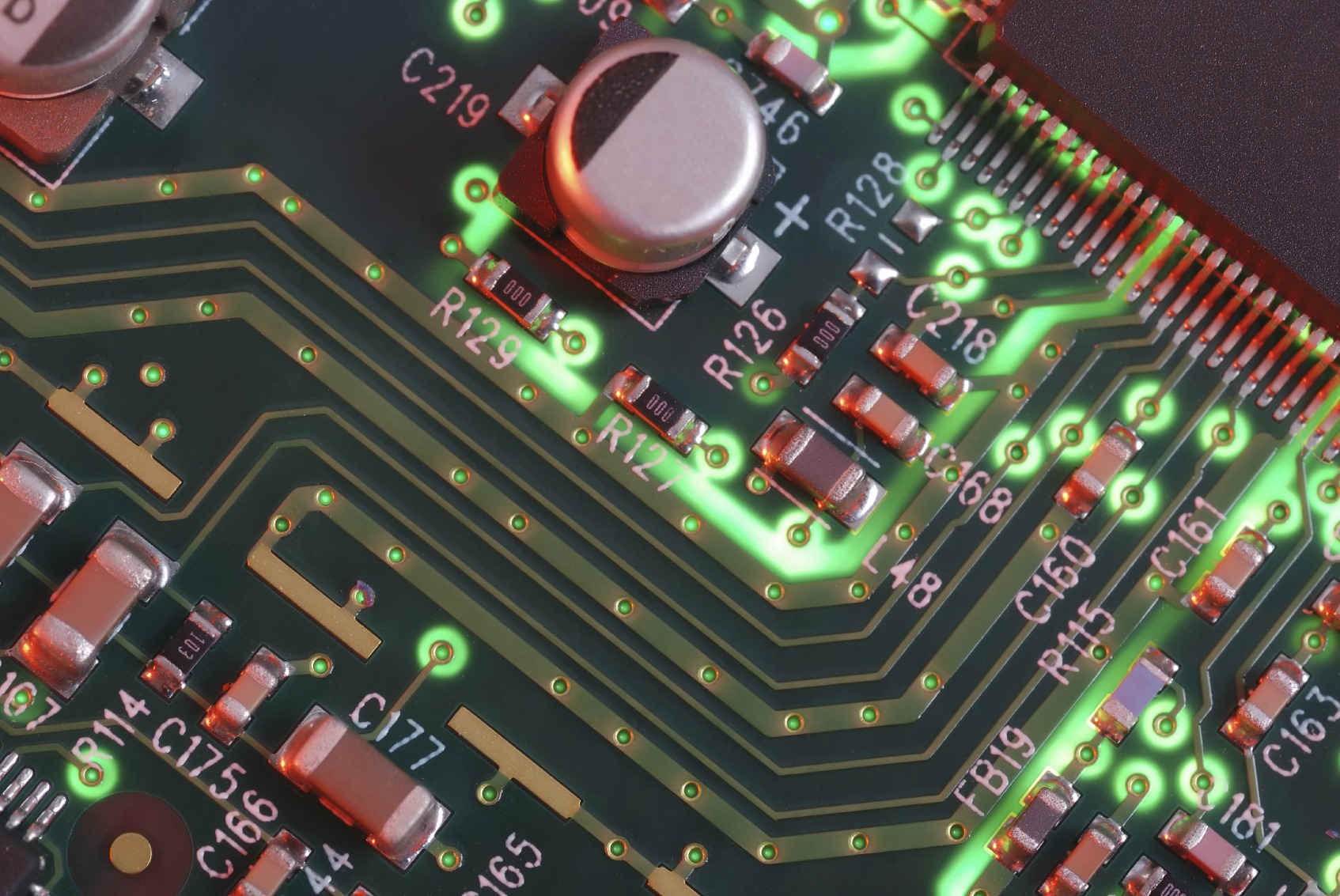 Close-up of a circuit board showcasing intricate green pathways and various electronic components, highlighting essential connections in electronics design.