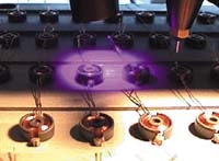 A precision instrument applies focused light to a microchip with multiple components, highlighting the technology's intricate detail and functionality.